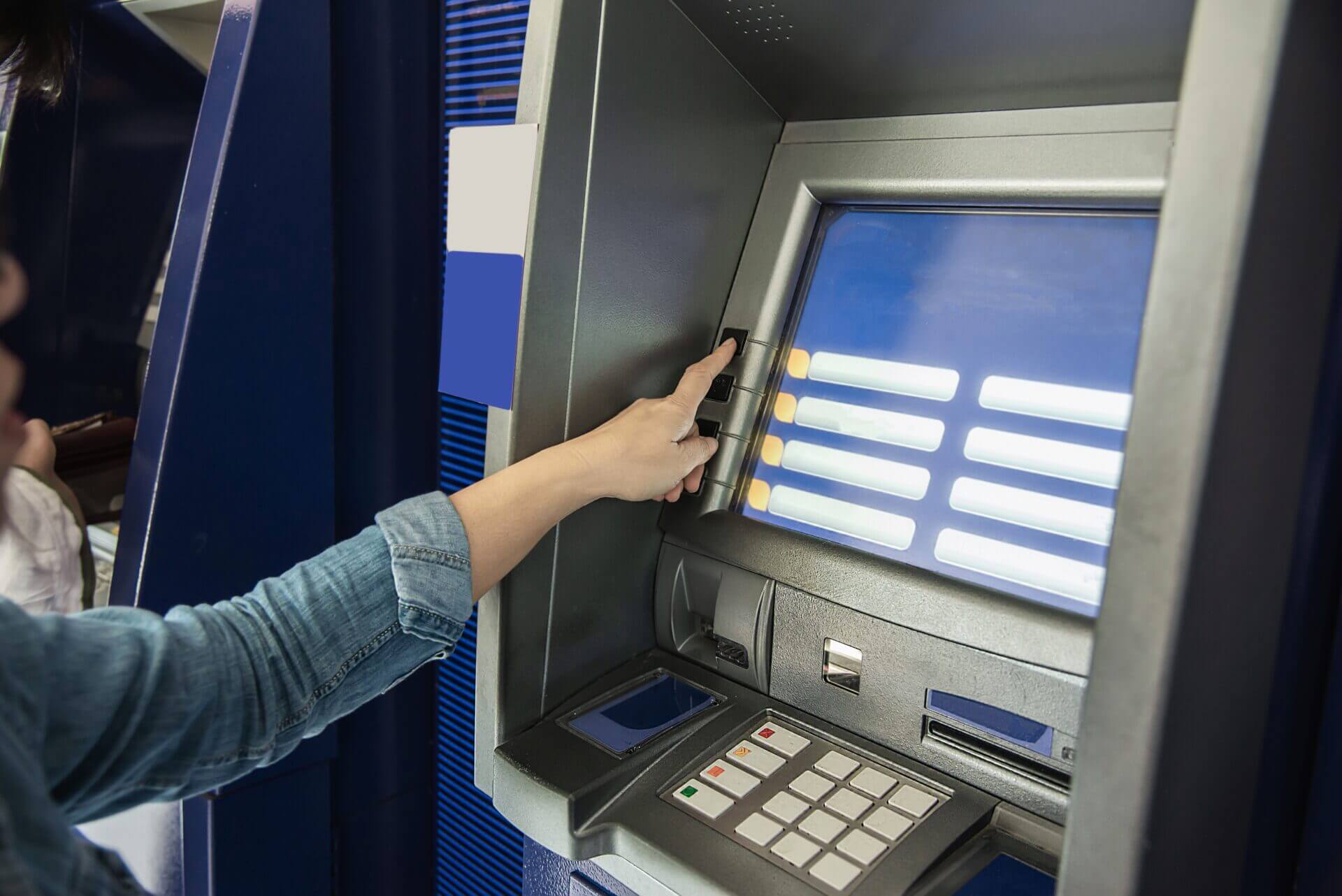 Pessoa fazendo algum tipo de transação em um caixa eletrônico de banco.