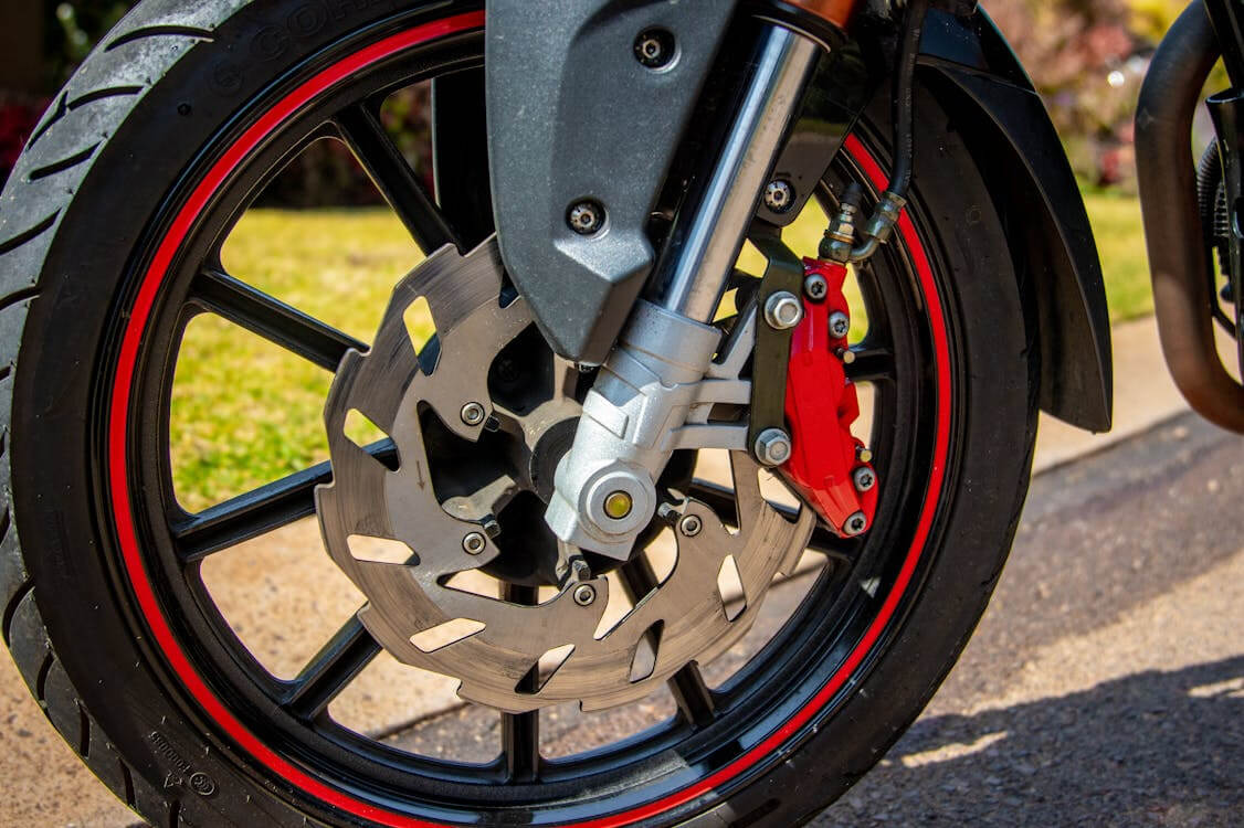 Roda de uma moto cm aro de cor vermelha.