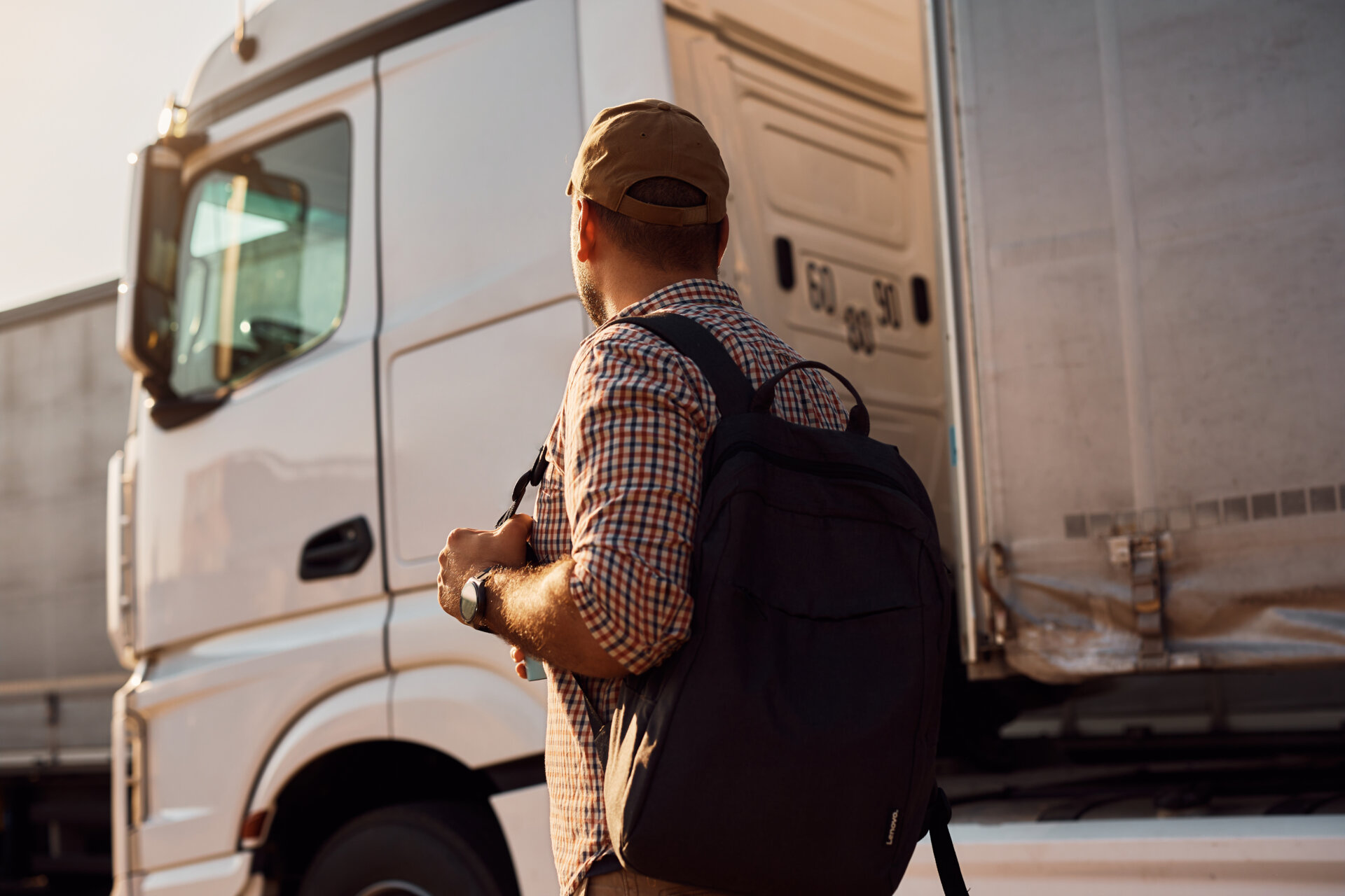 motorista de caminhão parado ao lado de seu veículo.