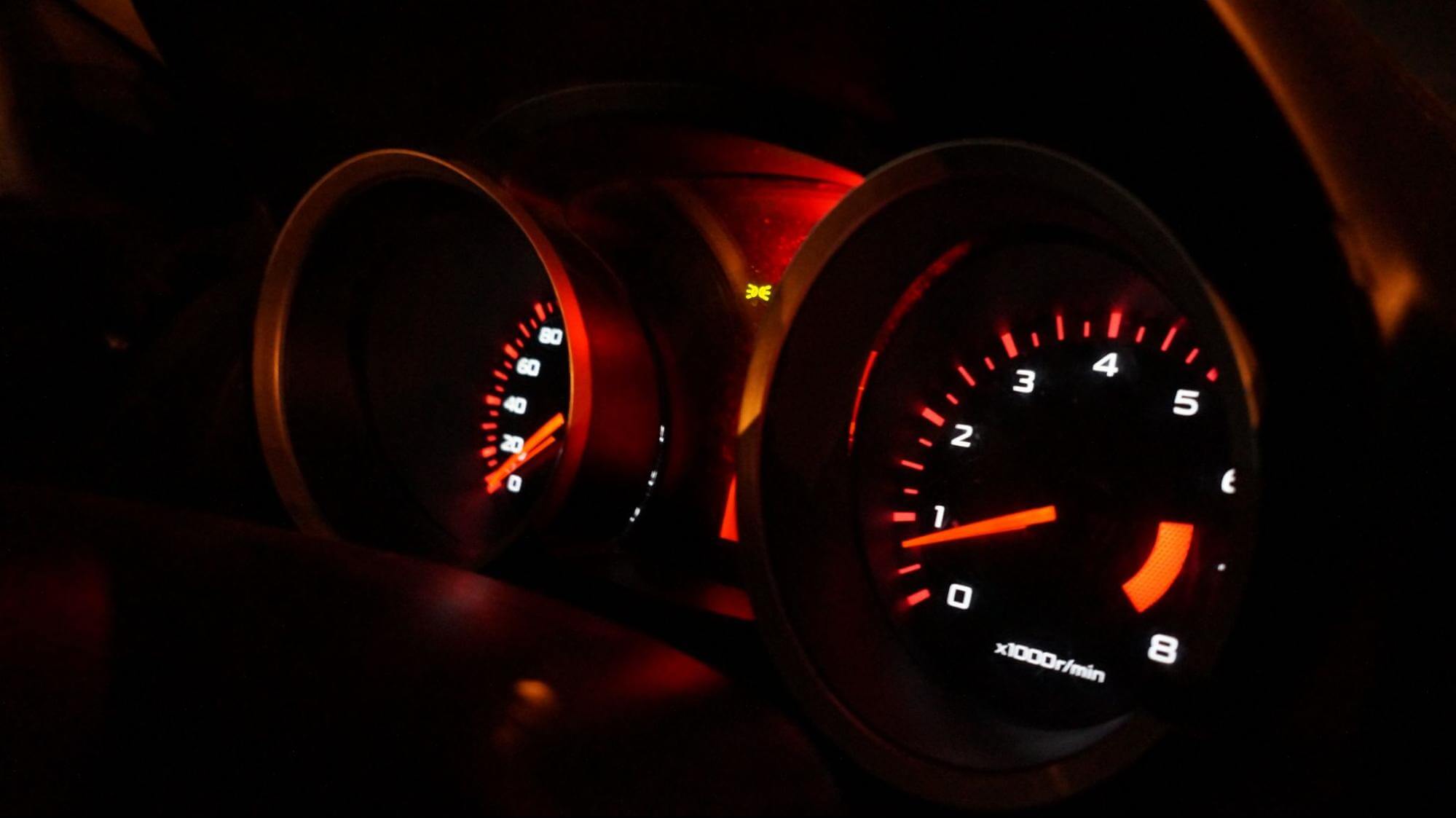o painel de gasolina e velocidade de um veículo está aceso, e demonstra seus ponteiros através de luzes avermelhadas