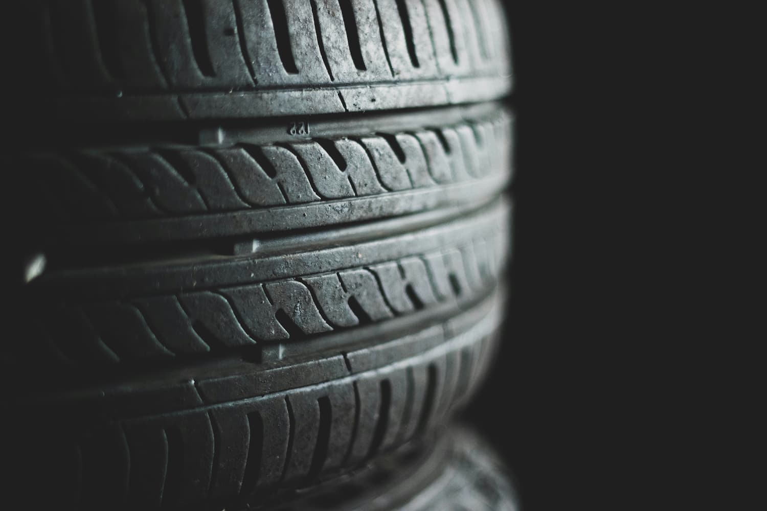Detalhe dos sulcos na banda de rodagem de um pneu, essenciais para a tração e segurança do veículo.