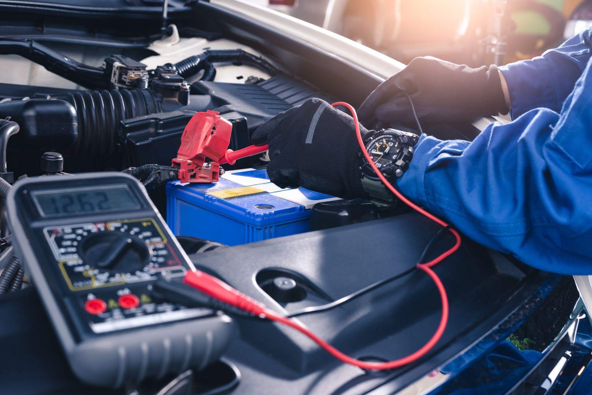 Mecânico fazendo uma chupeta numa bateria automotiva.
