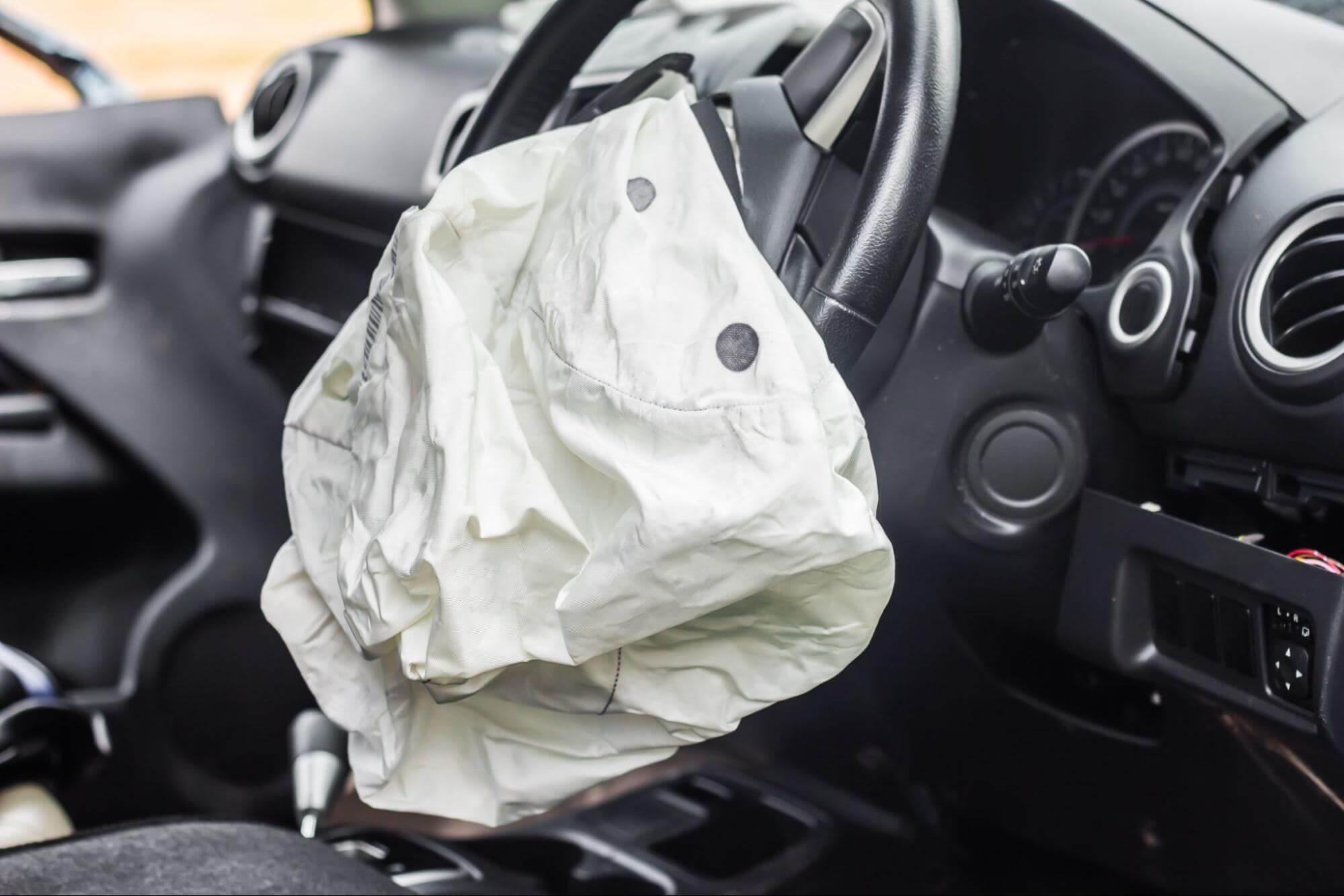 Interior de um carro com o airbag do volante murcho.
