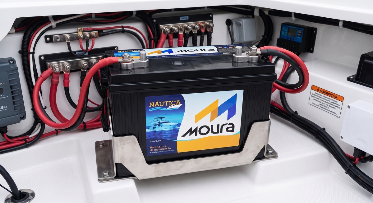 Bateria Náutica Moura de 150Ah instalada com segurança no compartimento elétrico branco de um barco. 